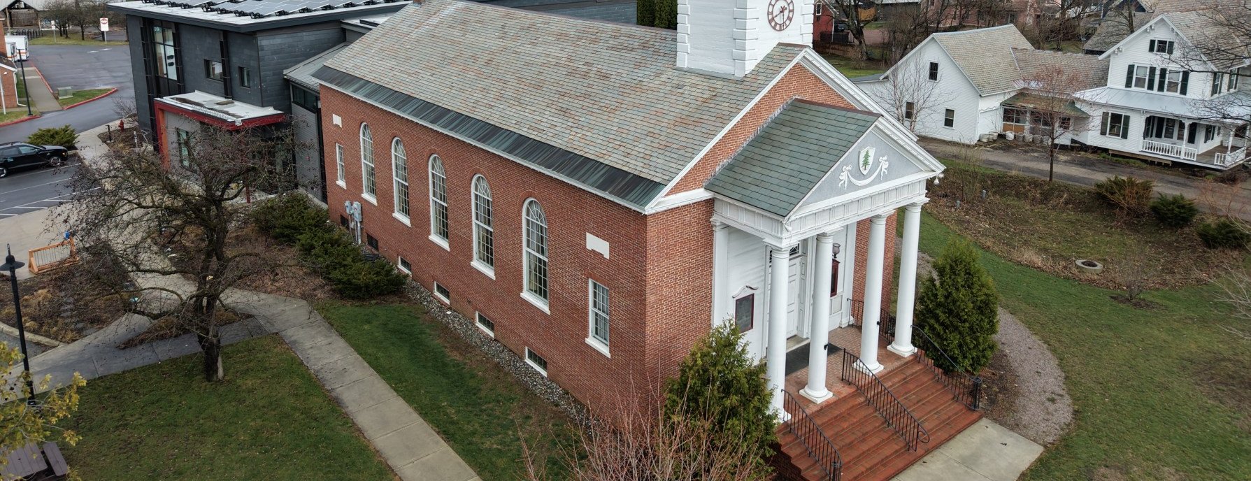 Shelburne Town Hall from the air — the 1927 Neoclassical brick building with its white cupola and clock, stop 1 on the walking tour