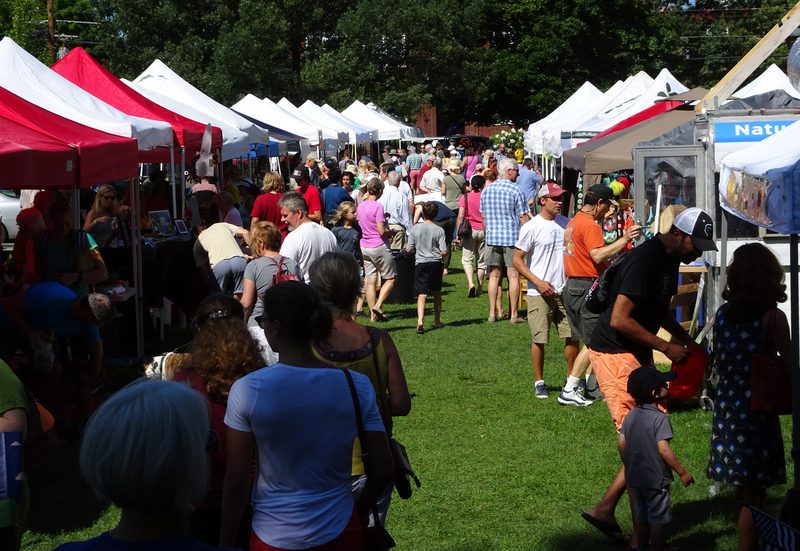 Crowds walking between vendor tents on the Parade Grounds